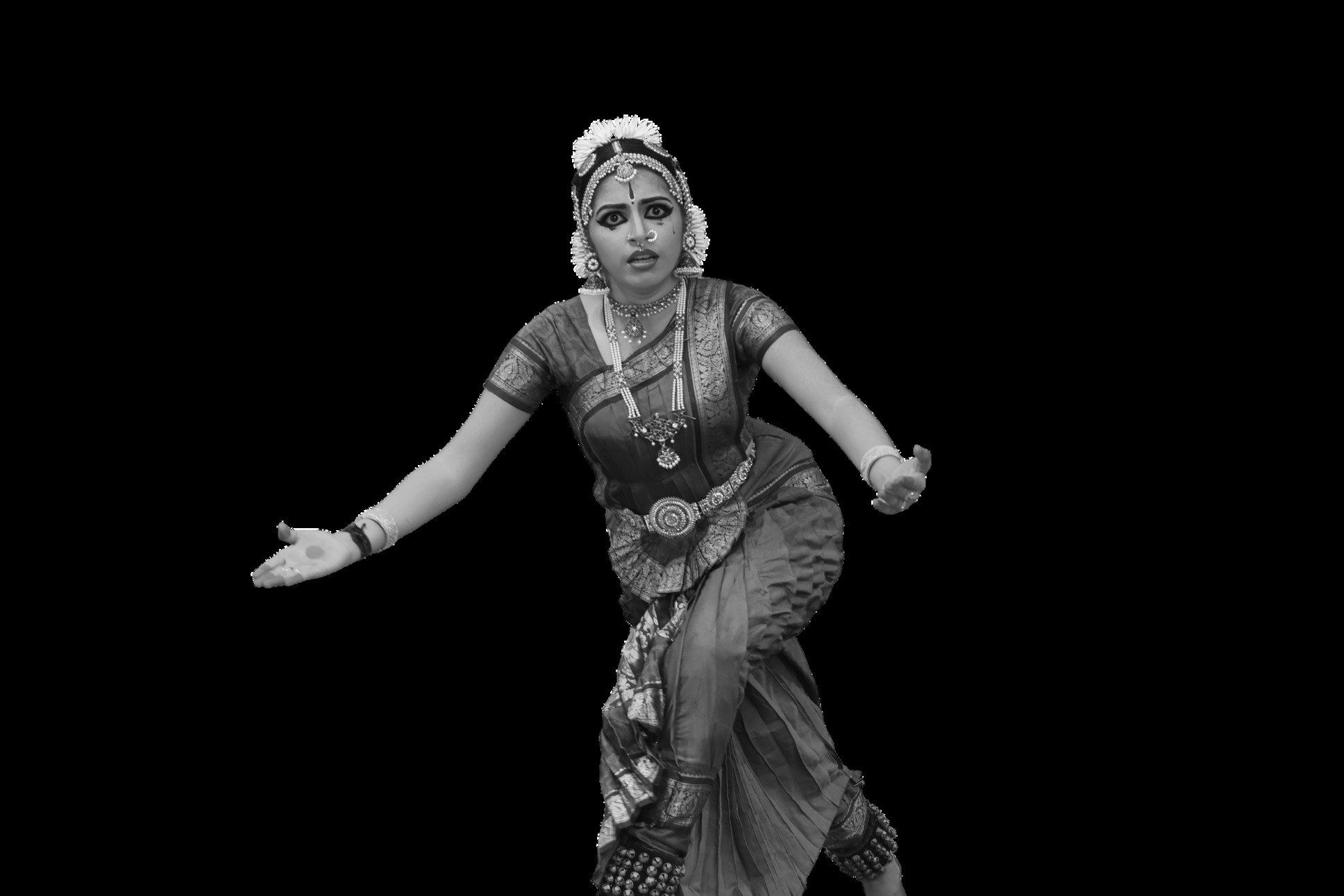 Medha Mayuri in monochrome, mid-pose, against a dark ground.